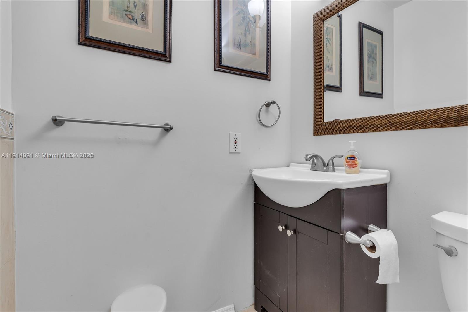 10930 Southwest 75th Street Miami, FL 33173 - Photo 17 of 34 a bathroom with a sink mirror and toilet