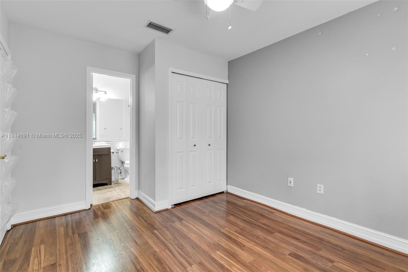 10930 Southwest 75th Street Miami, FL 33173 - Photo 19 of 34 an empty room with wooden floor and entrance