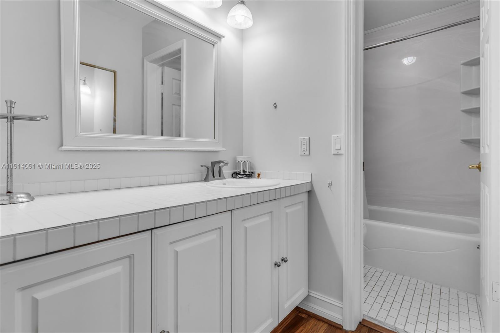 10930 Southwest 75th Street Miami, FL 33173 - Photo 21 of 34 a bathroom with a sink a mirror and a bathtub