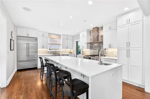 a kitchen with stainless steel appliances cabinets and wooden floor