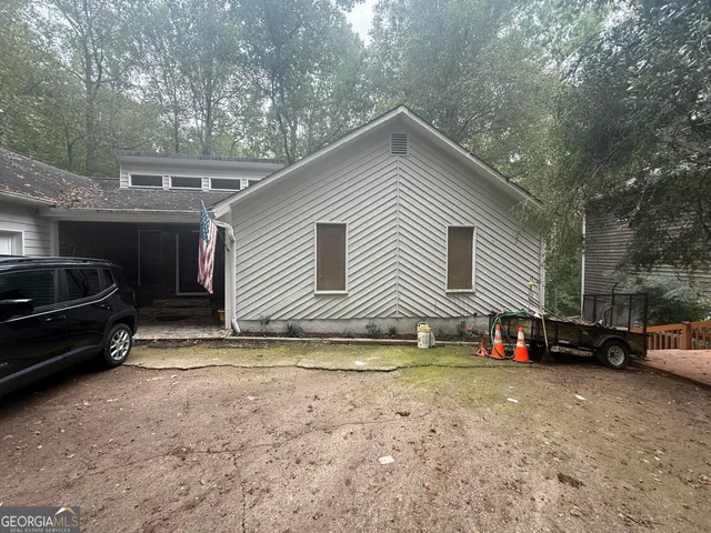 a view of a house with a cars park side of a road
