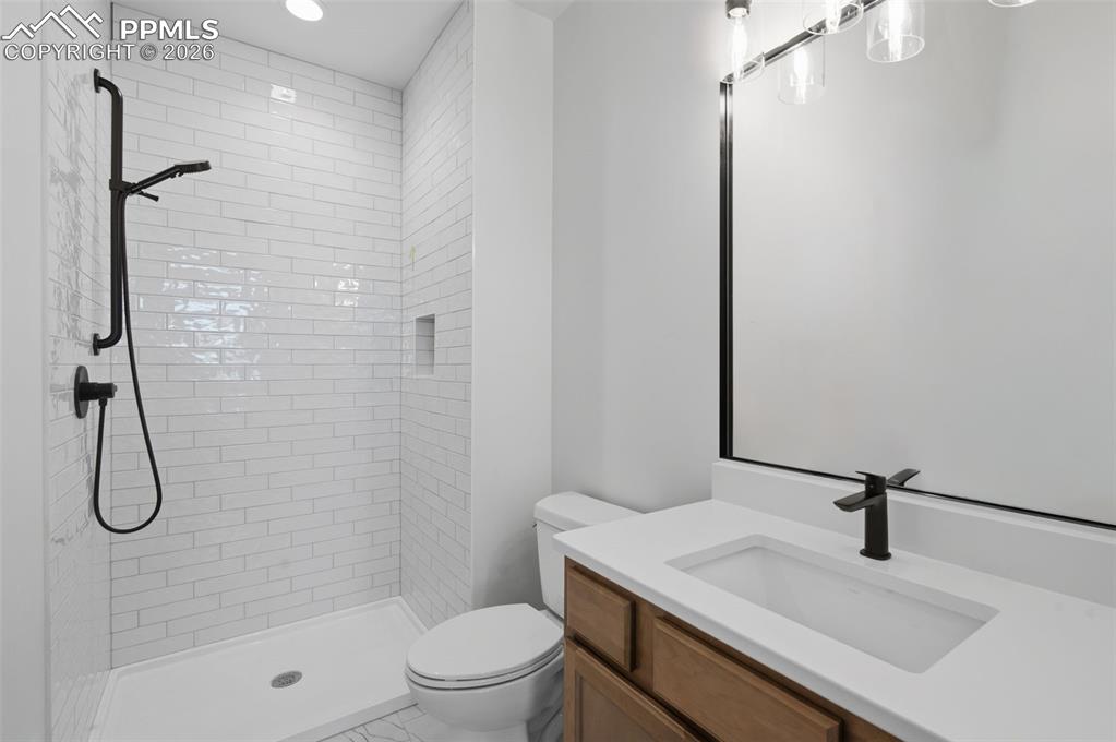 11293 Est Rdg Drive Peyton, CO 80831 - Photo 20 of 50 a bathroom with a granite countertop sink a toilet and shower