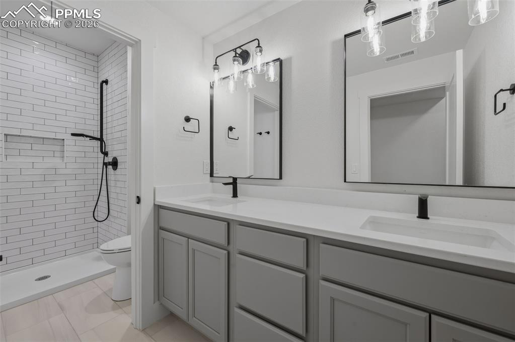 11293 Est Rdg Drive Peyton, CO 80831 - Photo 31 of 50 a bathroom with a double vanity sink mirror double and shower