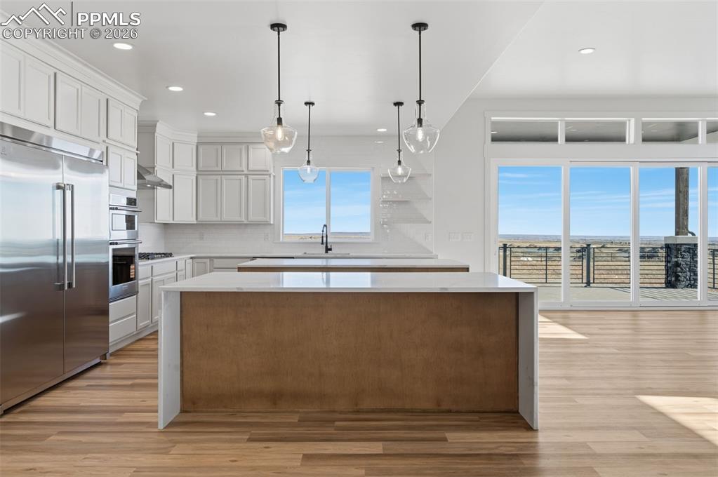 11293 Est Rdg Drive Peyton, CO 80831 - Photo 8 of 50 a large kitchen with kitchen island a large counter top and stainless steel appliances