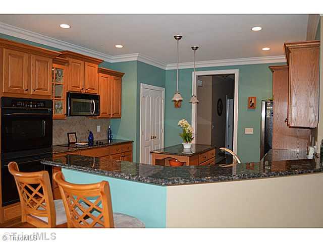 7083 Lanier Road Summerfield, NC 27358 - Photo 4 of 25 Kitchen. Double Ovens, pantry, cook top, bar counter, great workspace overlooking peaceful view of lake.
