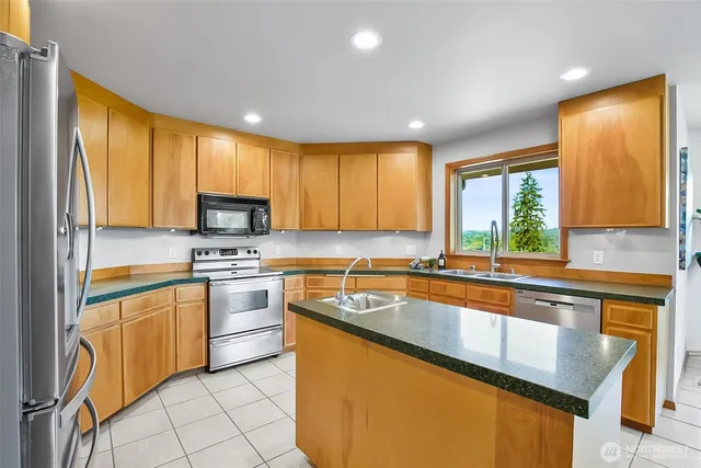 a kitchen with stainless steel appliances granite countertop sink stove top oven and cabinets