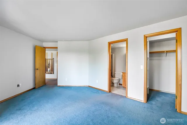 a view of an empty room with closet and a window