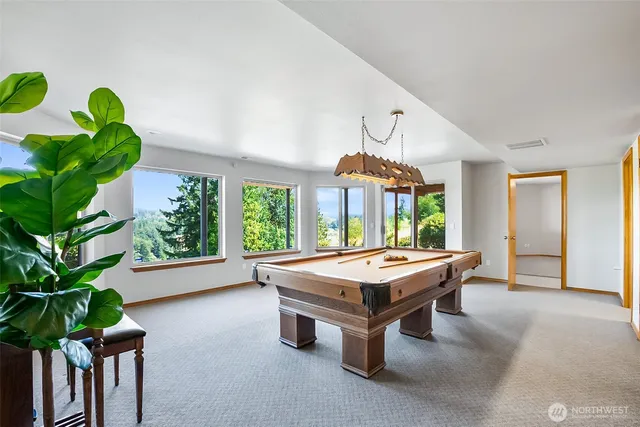a room with pool table and windows