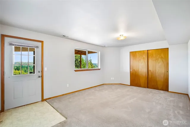 an empty room with windows and closet