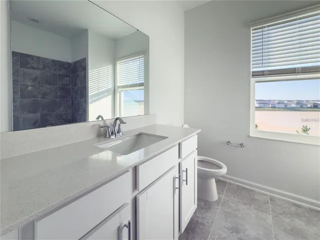 a bathroom with a sink toilet and window