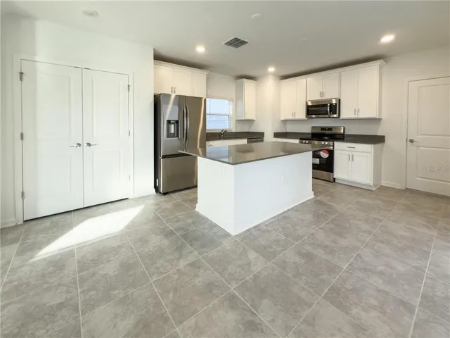 a kitchen with stainless steel appliances a refrigerator sink and cabinets