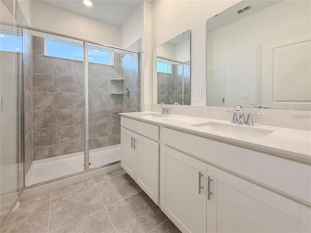 a bathroom with a shower sink and mirror