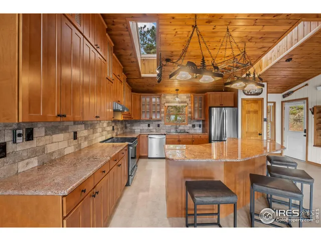 a kitchen with stainless steel appliances kitchen island granite countertop a sink and cabinets