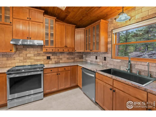 a kitchen with stainless steel appliances granite countertop a sink stove and cabinets