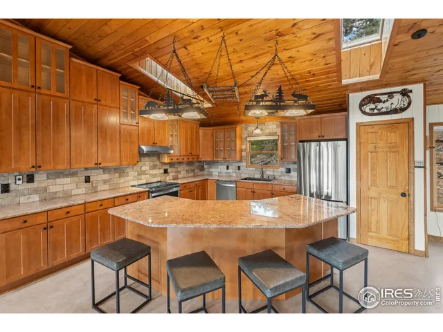 a dining area with stainless steel appliances a sink and chairs