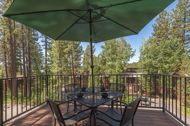 a view of a balcony with chairs and an umbrella