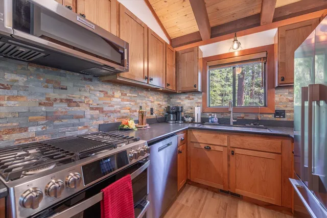 a kitchen with a stove a sink and wooden cabinets