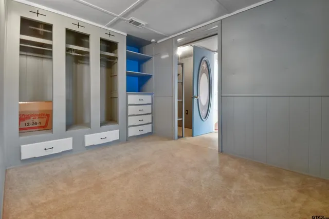 a view of an empty room with closet and a window