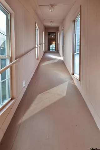 a view of a hallway with wooden floor and windows