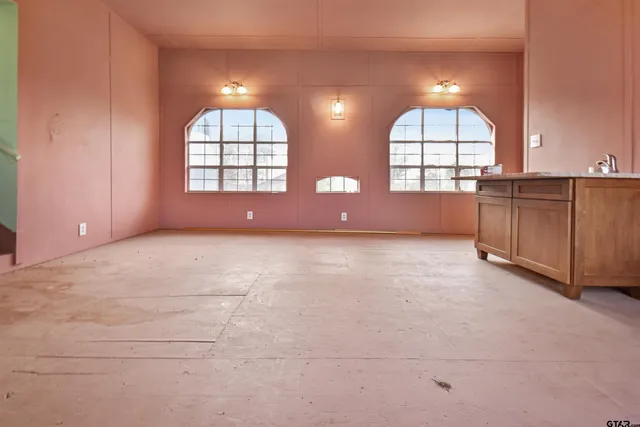 an empty room with windows and chandelier