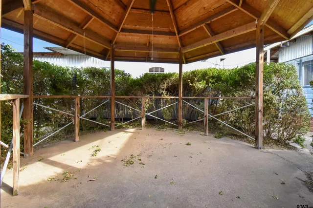a view of a backyard with table and chairs under an umbrella