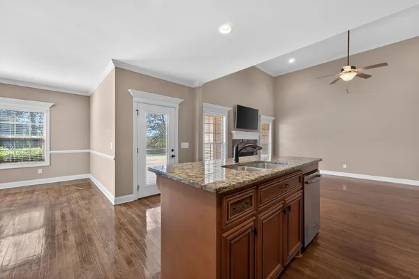 a kitchen with kitchen island a counter space a sink appliances and cabinets