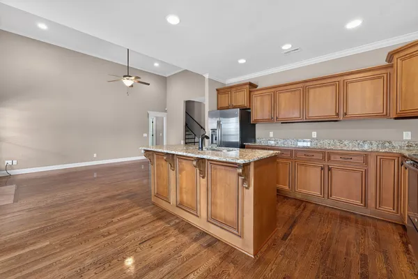 a kitchen with granite countertop a sink cabinets and wooden floor