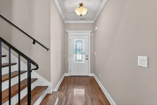 a view of a hallway with wooden floor and staircase