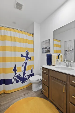 a bathroom with a sink mirror and a toilet