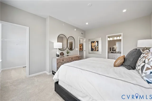 a bedroom with a bed and a lamp on dresser