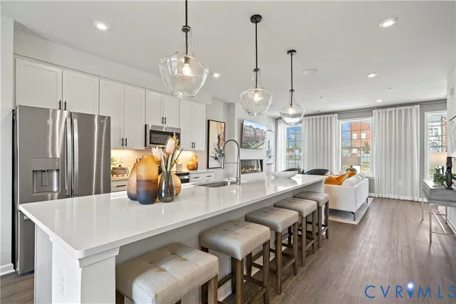 a large kitchen with sink a refrigerator and chairs