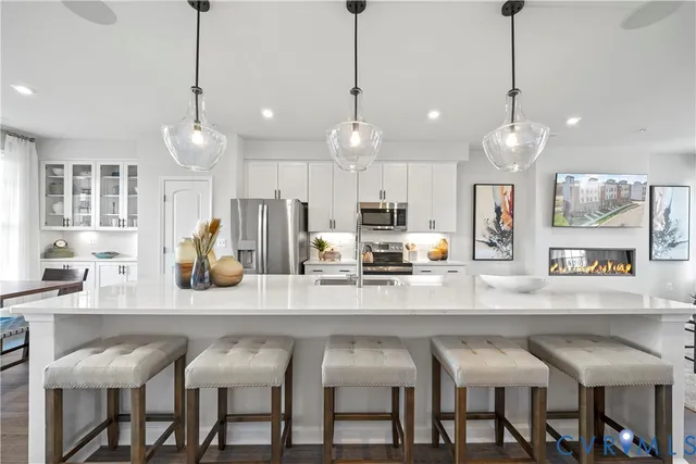 a kitchen with stainless steel appliances granite countertop a table chairs and chairs