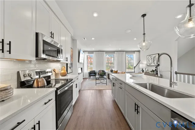 a large kitchen with stainless steel appliances lots of counter space and a sink
