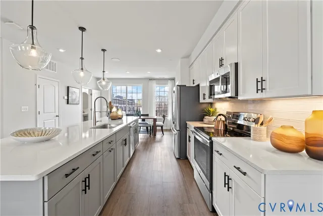 a kitchen with stainless steel appliances granite countertop a lot of counter space and wooden floor