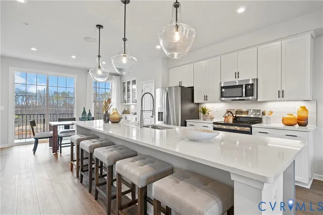 a large kitchen with sink a center island stainless steel appliances and furniture