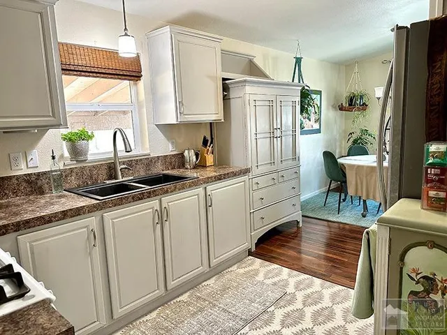 a kitchen with granite countertop a sink stove and cabinets
