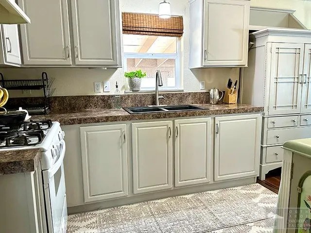 a kitchen with white cabinets and white appliances