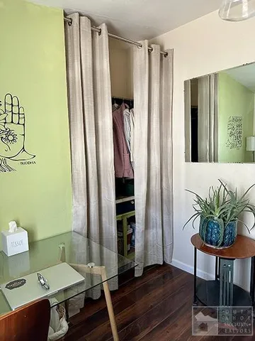 a bedroom with a bed and wooden floor