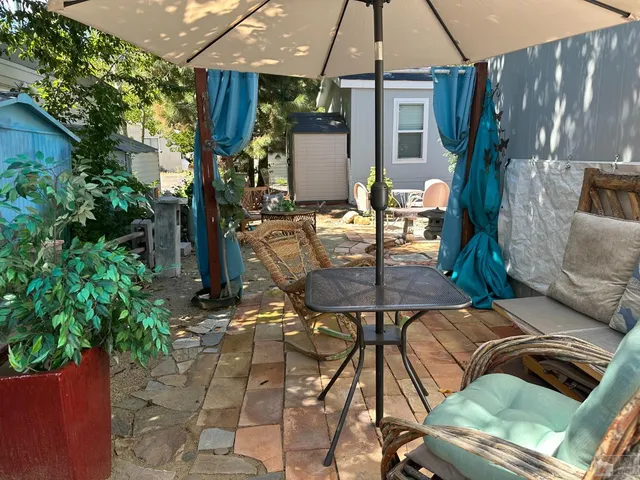 a view of patio with lawn chairs under an umbrella