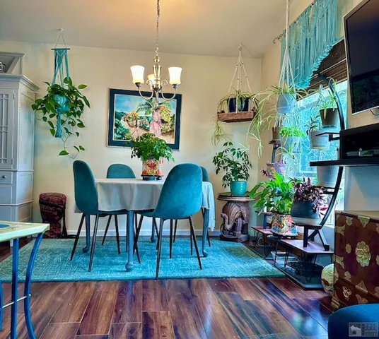 a dining room with furniture potted plants and wooden floor