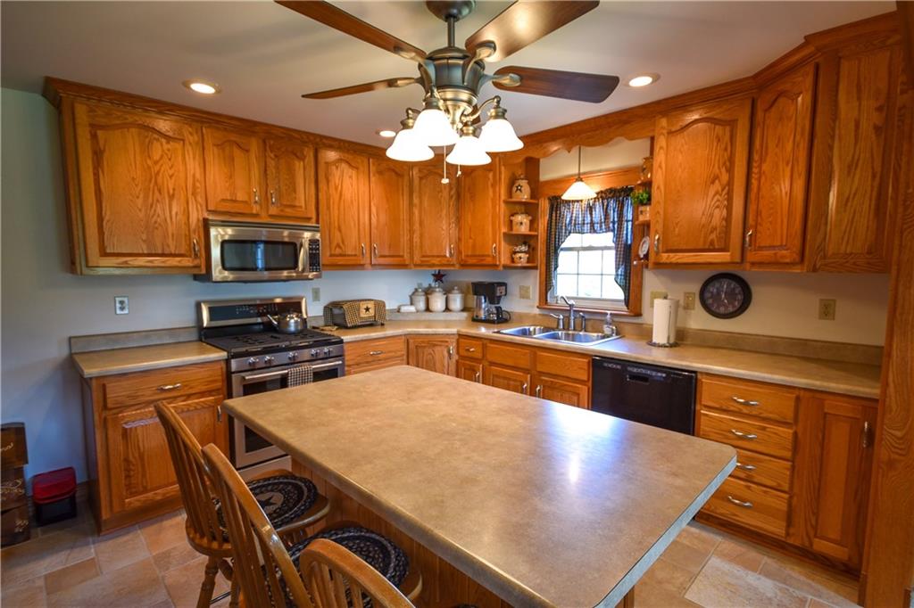 531 White Oak Road Rural Valley, PA 16249 - Photo 10 of 39 a kitchen with stainless steel appliances a stove a sink a microwave a dining table and chairs