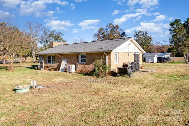 a front view of house with yard and trees in the background