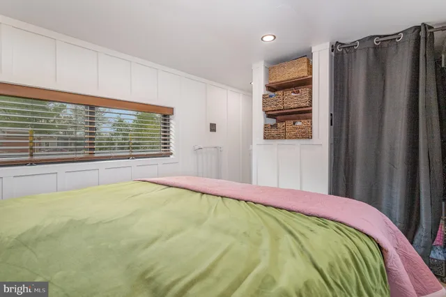 a bed sitting in a bedroom next to a window