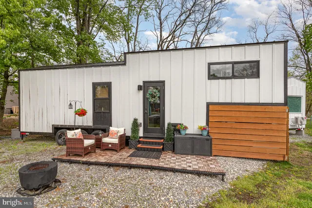 a backyard of a house with barbeque oven table and chairs