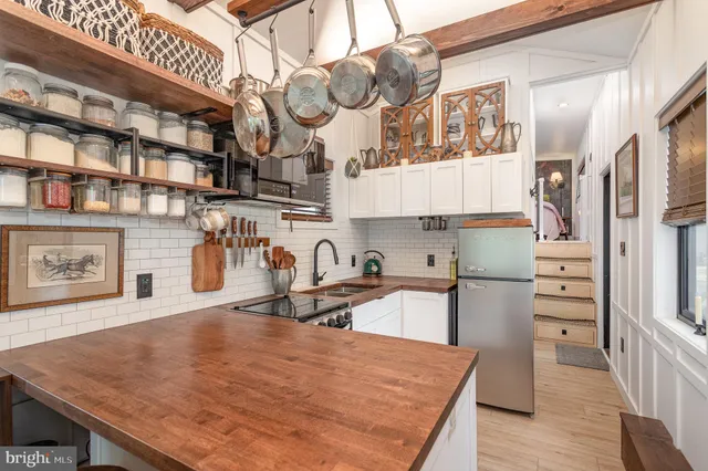 a kitchen with stainless steel appliances granite countertop a sink a stove and a wooden floors