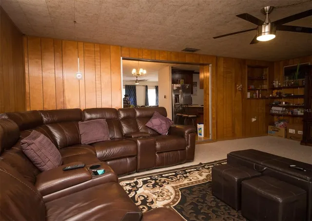 a living room with furniture ceiling and flat screen tv