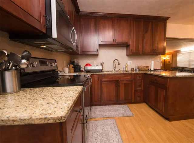 a kitchen with stainless steel appliances kitchen island granite countertop a sink stove and cabinets