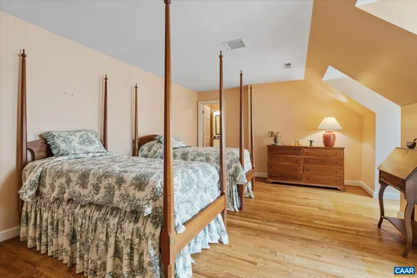 a bedroom with bed and wooden floor