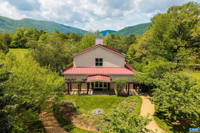 an aerial view of green landscape with trees houses and mountain view
