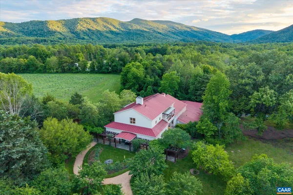 an aerial view of green landscape with trees houses and mountain view